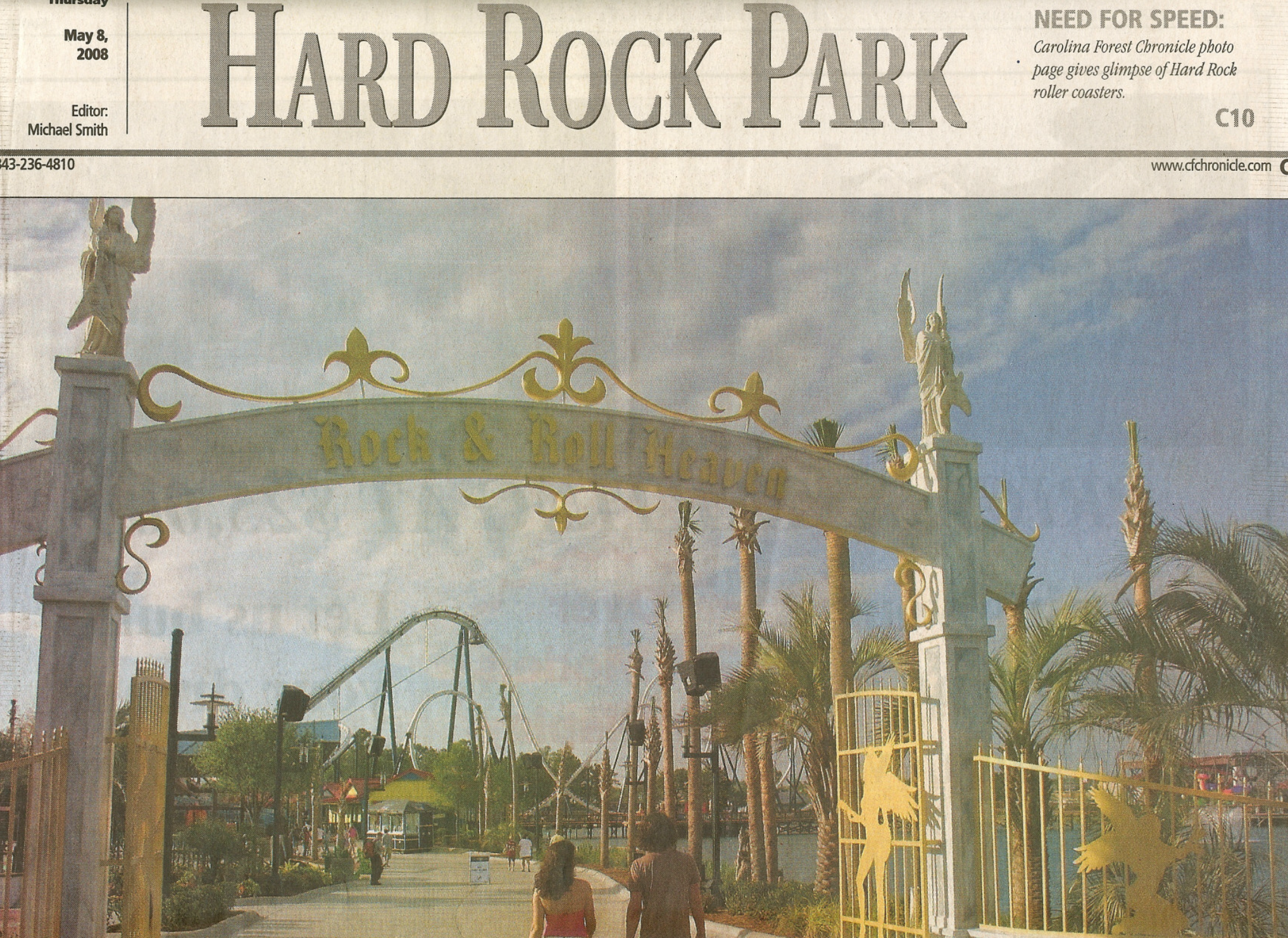 Hard Rock Park entrance arch, palm trees, statues, roller coasters.